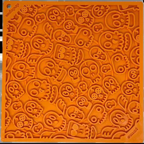 Orange silicone baking mat with embossed skull patterns for slow feeding and mental stimulation.
